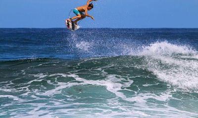 Ein Surfer macht auf Portugal Sprachreise einen Sprung im Wasser