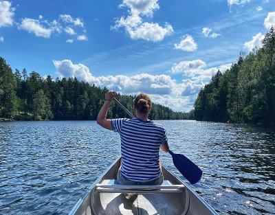 Eine Teilnehmerin paddelt mit dem Kanu über das Wasser im Abenteuer Forschercamp