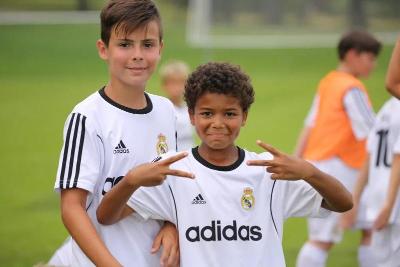 Ein Junge zeigt im Fußball-Camp mit seinen Händen Peace