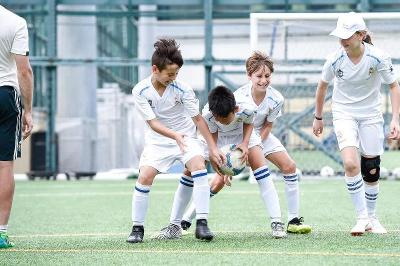 Die Teilnehmer vom Fußball-Camp wärmen sich mit einem lustigen Spiel auf