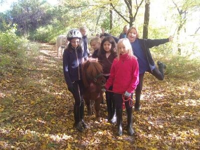 Die Kinder haben während der Reitferien Hessen Spaß im Wald mit den Tieren
