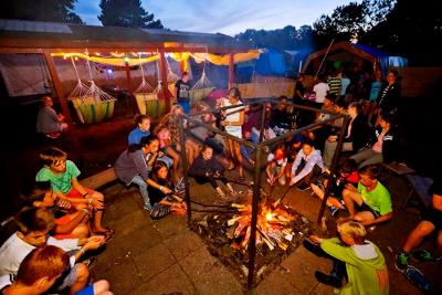 Jugendliche sitzen am Abend ums Feuer herum auf der Jugendreise Ostsee