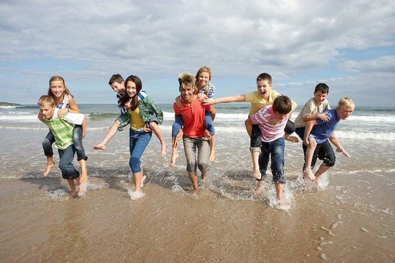 Kinder spielen gemeinsam am Strand im Ferienlager Peenemünde