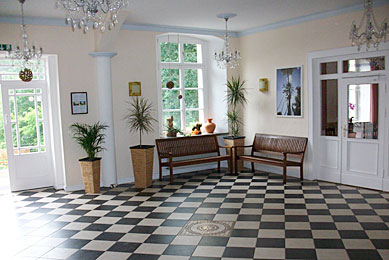Das Foyer im Schloss Gadow schwarz weisse Fließen und Kronleuchter stechen hervor