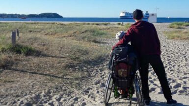 Mensch im Rollstuhl am Strand
