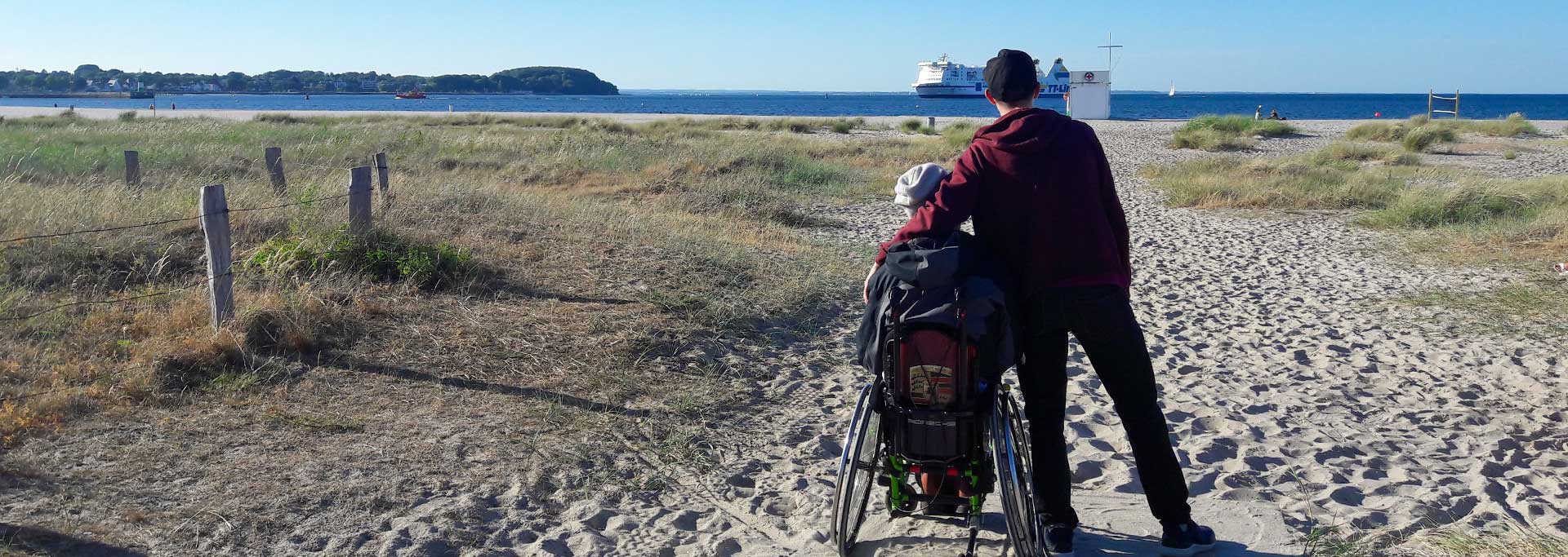 Mensch im Rollstuhl am Strand
