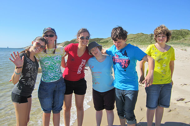 Eine Reisegruppe am Strand auf einer inklusiven Reise