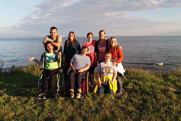 Eine Reisegruppe auf der Wiese am Wasser auf einer inklusiven Reise